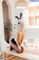 A woman in a bunny costume sitting on a table.